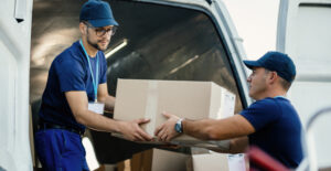 Equipe de logística realizando carga de mercadoria para evitar multas no DER com transporte regularizado