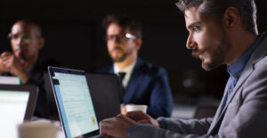Profissional analisando dados em reunião sobre o que sua empresa precisa saber para estar em conformidade